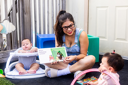 babies exploring reading together in a cozy environment supporting early reading daycare Kyle
